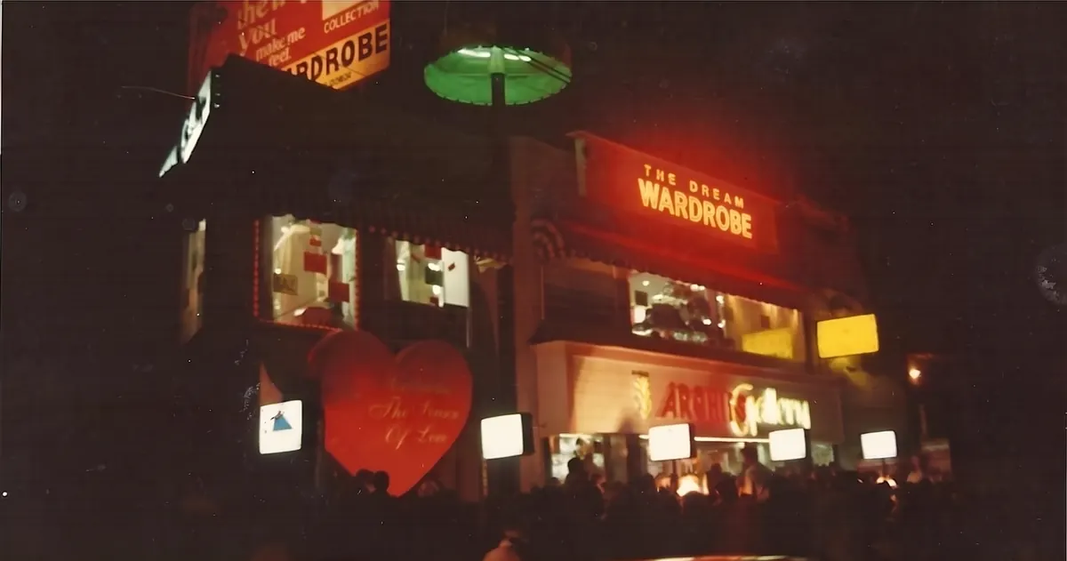 Wardrobe and Archies Gallery lit up at night on Lawrence Road Extension in 1995, with a crowd outside